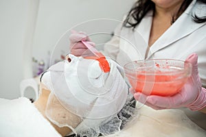 Cosmetologist doing procedure with alginate mask for anti-aging treatment face her female client