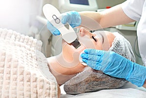 Cosmetologist doing ultrasound face peeling