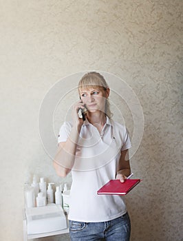 a cosmetologist girl consults a client by phone. pre-registration photo