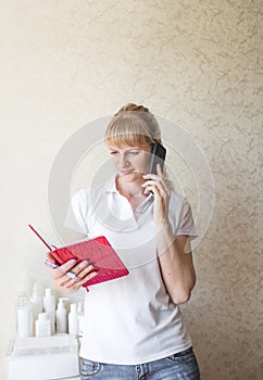 a cosmetologist girl consults a client by phone. pre-registration photo