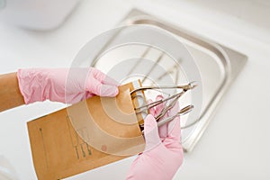 Cosmetologist in gloves holds manicure equipment