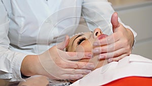 Cosmetologist is going face mask . peeling for young woman. Woman is having cosmetology procedure