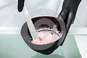 Cosmetologist hands preparing alginate mask