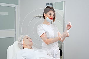 Cosmetologist holds syringe filled with gel medication