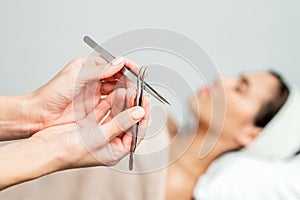 Cosmetologist holds tweezers for eyelash extensions