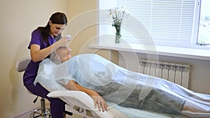 The cosmetologist makes the apparatus a procedure of ultrasound cleaning of skin
