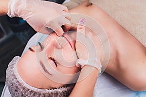 Cosmetologist makes a buccal massage of the patient`s facial muscles.