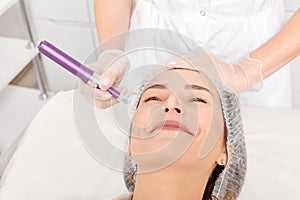 Cosmetologist makes mesotherapy injection for rejuvenation woman face, procedure in beauty salon