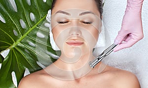 The cosmetologist makes the  Microdermabrasion procedure of the facial skin of a woman in a beauty salon.Cosmetology and