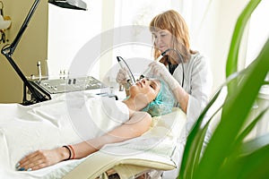 Cosmetologist makes the procedure microcurrent therapy beauty salon