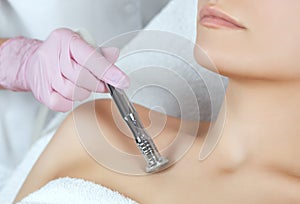 The cosmetologist makes the procedure Microdermabrasion of the decollete skin photo