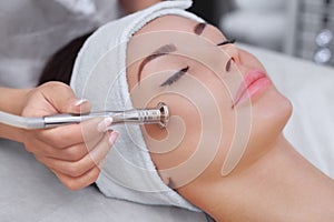 The cosmetologist makes the procedure Microdermabrasion of the facial skin