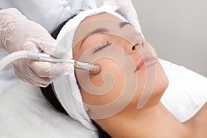 The cosmetologist makes the procedure Microdermabrasion of the facial skin