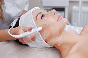 The cosmetologist makes the procedure treatment of Couperose of the facial skin photo