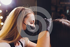 Cosmetologist making eyebrows design. Attractive woman getting facial care at beauty salon. Perfect architecture