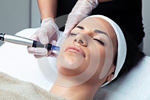 Cosmetologist making mesotherapy injection with dermapen on face for rejuvenation on the spa center