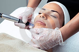 Cosmetologist making mesotherapy injection with dermapen on face for rejuvenation on the spa center