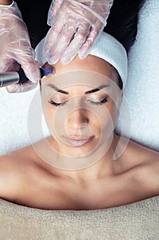 Cosmetologist making mesotherapy injection with dermapen on face for rejuvenation on the spa center