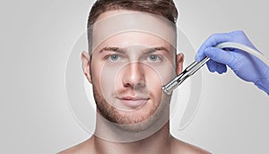 A cosmetologist is making the procedure Microdermabrasion of the facial skin in a beauty salon.