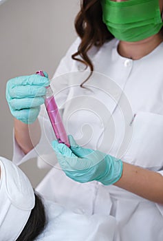 Cosmetologist with a Pink Microneedling Dermapen photo