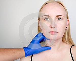 A cosmetologist prepares the patient for surgery: contour plastics of the neck, mesotherapy or botulinum therapy. Wrinkles and