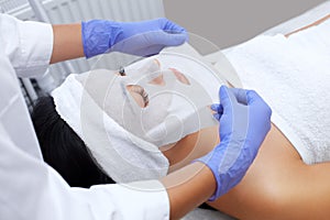 Kosmetolog postup z čištění hydratační kůže použití list na z mladá žena v elegán 