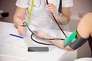 Cosmetology beauty clinic. doctor checking patient`s blood pressure, close-up of the patient`s hand