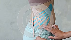 Cosmetology kinesio tapes on young woman waist.