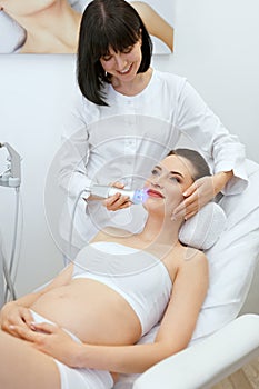 Cosmetology. Pregnant Woman At Face Skin Stimulation Procedure