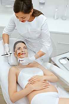 Cosmetology. Pregnant Woman Getting Facial Beauty Procedure