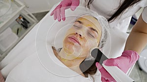 Cosmetology procedures for facial skin in a beauty salon. Beautiful young woman in a beauty clinic. A cosmetologist