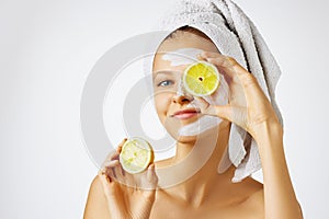 Cosmetology, skin care, face treatment, spa and natural beauty concept. Woman with facial mask holds lemons