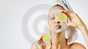 Cosmetology, skin care, face treatment, spa and natural beauty concept. Woman with facial mask holds lemons