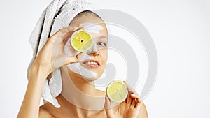 Cosmetology, skin care, face treatment, spa and natural beauty concept. Woman with facial mask holds lemons