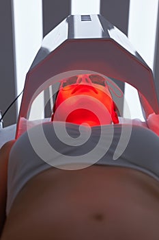 Cosmetology. Woman Face At Red Light Treatment At Beauty Clinic