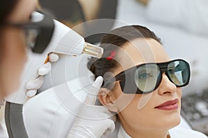 Cosmetology. Woman At Hair Growth Laser Stimulation Treatment