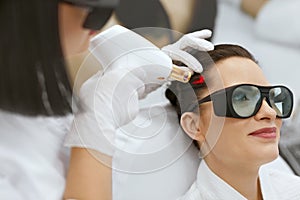 Cosmetology. Woman At Hair Growth Laser Stimulation Treatment