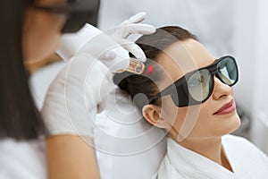 Cosmetology. Woman At Hair Growth Laser Stimulation Treatment photo
