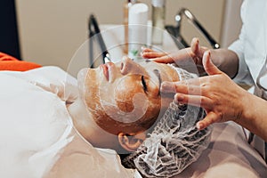 Cosmetology. Woman is having face mask in cosmetology cabinet.