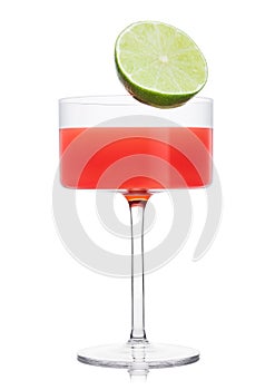Cosmopolitan cocktail in modern crystal glass with lime half on white