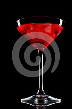 Cosmopolitan cocktail in nice red color in front of a black background