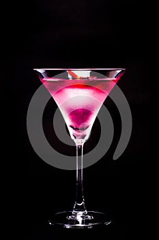 Cosmopolitan cocktail with rose in top of a black