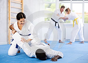 Cosmopolite sportsmen train of performing protection with wring hands during training in aikido