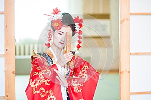 Cosplay. beautiful, modest geisha in a red kimono