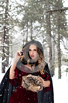 Cosplay model portrait in a winter forest. Snow white, red riding hood, medieval model cosplay