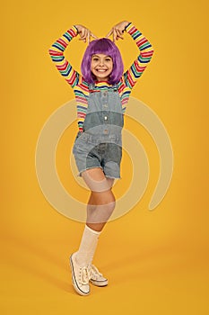 Cosplay outfit. Otaku girl in wig smiling on yellow background. Cosplay character concept. Culture hobby and