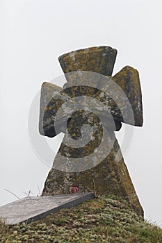 Cossack`s grave on the hill. Old stone cross. Green grass