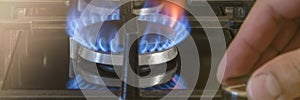 The cost of gas for domestic needs. The hand unscrews the gas burner in the kitchen. The use of gas as home heating in