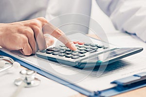 Cost of health care concept, stethoscope and calculator on table