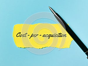 Cost per acquisition written on yellow paper strip with a pen.